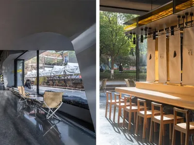 An industrial-style restaurant interior featuring wooden tables, metal chairs, and glass panels.