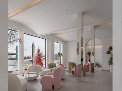Modern hotel lobby featuring sleek, pink, and white furniture.