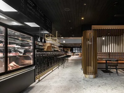 Industrial-style restaurant interior with black metal and wood finishes.