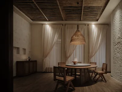 A restaurant interior featuring a round dining table surrounded by wooden chairs, with bamboo elements and muted lighting.