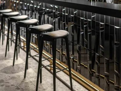 A modern industrial restaurant interior with a sleek, metallic bar counter.