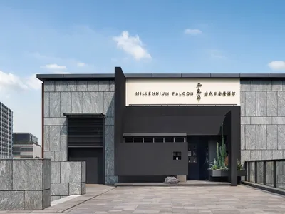 A minimalist restaurant exterior featuring a glass facade and modern design.