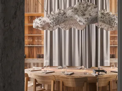 Circular wooden table with minimalistic decor and lighting in a modern restaurant setting.