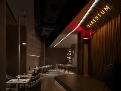 A modern restaurant interior with dark-toned materials and a sleek, contemporary design.