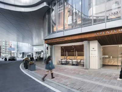 Modern restaurant with glass storefront and concrete entrance on a sidewalk.