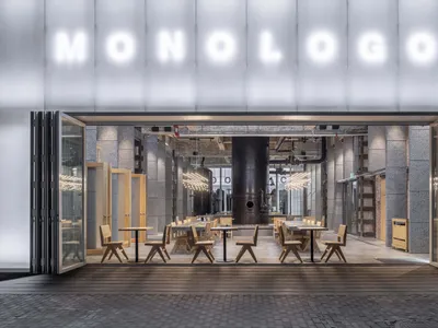 Industrial-style restaurant interior with metal, concrete, and glass materials.