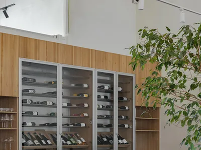 An industrial-style restaurant with wooden furniture, metal accents, and a wine storage cabinet.
