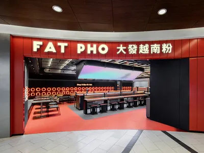 Interior of a modern food court with metal and red color scheme.