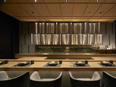 A modern restaurant interior featuring wood, glass, and marble materials.