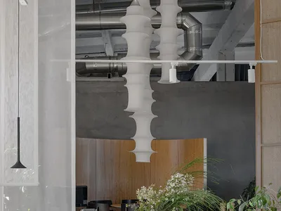 A modern restaurant kitchen featuring concrete walls and ceiling, with a minimalist design and industrial elements.