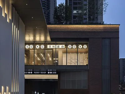 Modern restaurant exterior with brick, concrete, and warm lighting.
