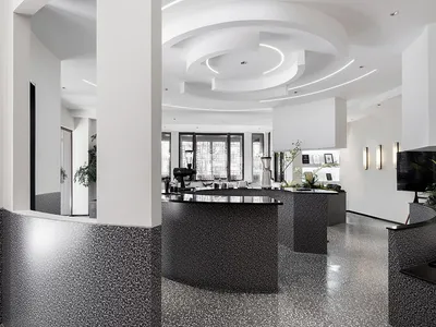 Modern restaurant interior with terrazzo flooring, minimalist design, and sleek black and white decor.