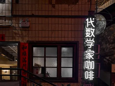 混凝土樓梯在夜間都市環境中被霓虹燈招牌照亮