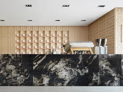 A minimalist industrial-style coffee shop counter showcasing black marble, concrete, and carved wood elements.