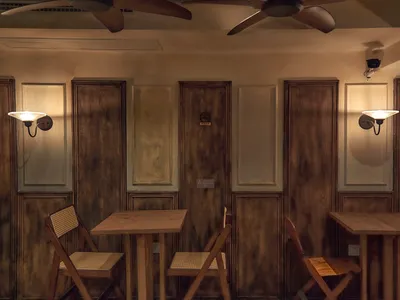 An industrial-style restaurant interior with wood paneling and tables.