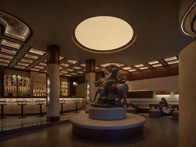 A modern industrial restaurant interior with a concrete ceiling and floor, featuring a statue of a lion and lioness riding a