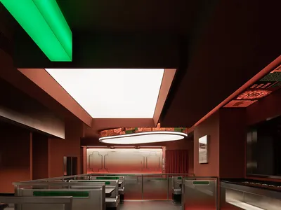 A modern, sleek restaurant with metallic frames and green and red lighting.
