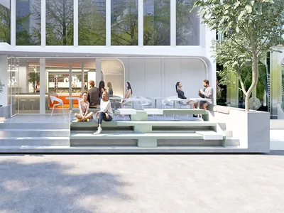 People sitting outside a modern restaurant with concrete and glass exterior.