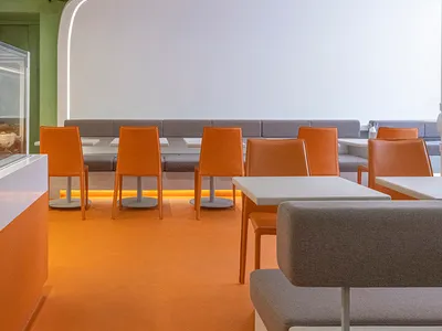Modern restaurant interior with concrete floating tables and seating