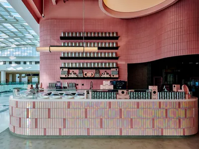 A ceramic-tiled cafe interior with a counter and shelving.