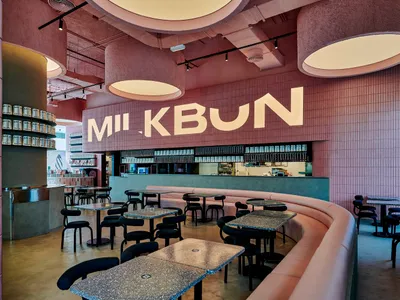Contemporary minimalist restaurant interior featuring pink concrete walls and pink tiled floors.