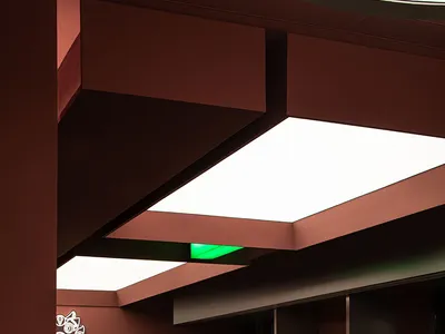 Interior of a modern restaurant featuring metal and glass ceiling panels.