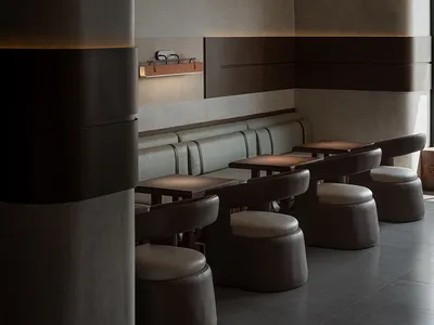 現代餐廳室內，搭配木質餐桌、皮革座椅與混凝土牆面。