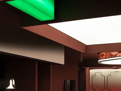 An interior view of a modern restaurant featuring metallic surfaces and green acrylic elements.