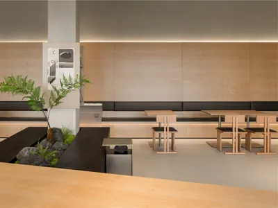 簡約風格的餐廳用餐區，搭配木質桌椅，並以植物與石頭裝飾點綴。