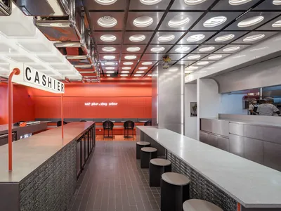 Modern restaurant interior with industrial lighting and metallic materials.