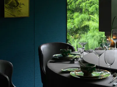 Modern restaurant interior with glass walls and study area.