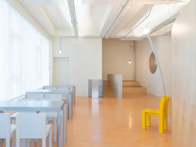 現代極簡餐廳室內，搭配白色家具與黃色餐椅。