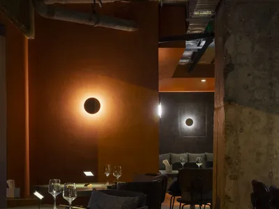 Industrial-style restaurant interior with concrete walls, wooden tables, and metal accents.