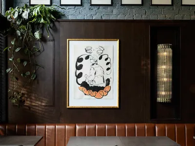 Restaurant interior with industrial design elements, wooden tables, leather booths, and brick walls.