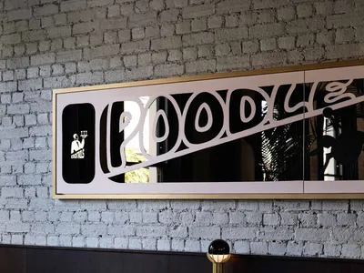 Industrial style restaurant interior with metal sign, leather seating, and brick wall