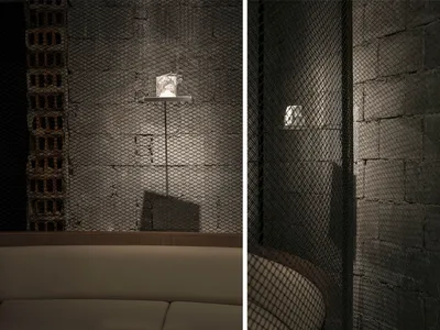 A modern restaurant interior with metal grid walls and concrete elements.