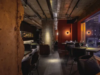 Interior view of a modern restaurant featuring exposed concrete walls and minimalist design.