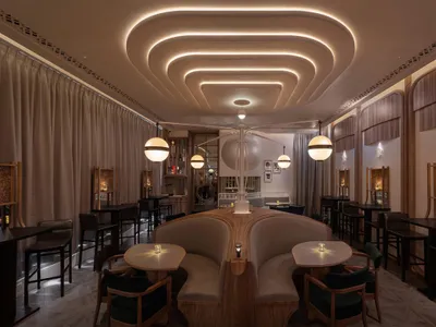 Contemporary restaurant bar with modern seating, elegant lighting fixtures, and fabric seating.
