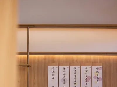 A modern restaurant interior with wooden panels featuring a menu card.