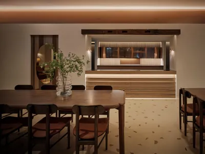 A modern restaurant bar with wooden furniture and warm lighting.