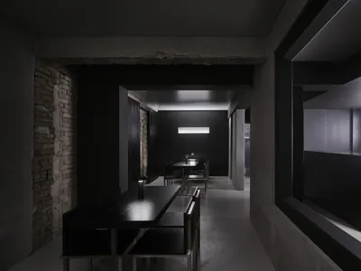 A minimalist restaurant interior featuring concrete and metal elements.