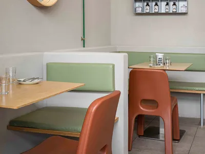 Minimalist restaurant interior with modern furniture and materials.