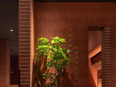 工業風餐廳入口，採用磚瓦、混凝土與盆栽植物。