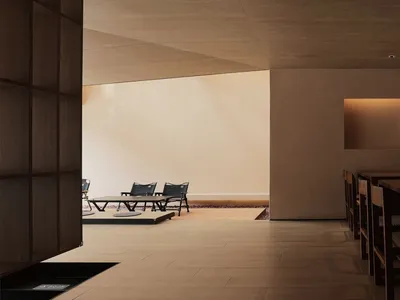 A minimalist restaurant interior with wooden tables and chairs