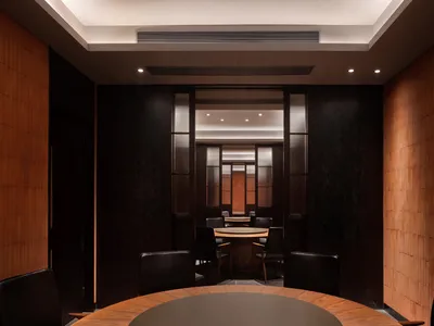 現代餐廳室內視角，展示木製餐桌椅、深色木牆，以及溫暖宜人的氛圍
