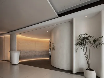 Modern, minimalist entryway featuring curved, concrete pillars with warm, ambient lighting.
