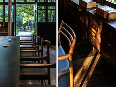 A modern restaurant interior with a long dining table and chairs, featuring wooden materials and a sense of tranquility.