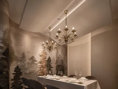 A modern restaurant dining room with neutral materials, featuring a long table set for dining, chandeliers, and nature-inspir