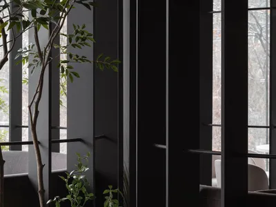 Modern, industrial-style restaurant interior with metal walls and green plants.