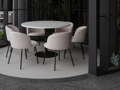 Circular table and chairs in a modern restaurant setting with artificial lighting hanging above.